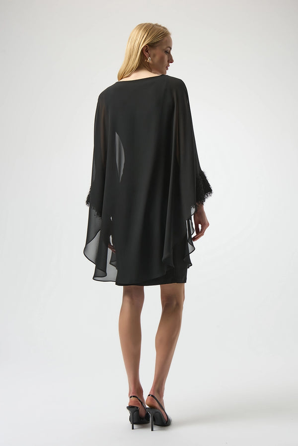 Joseph Ribkoff black silky knit and chiffon layered dress with fringe cuff detail, boat neckline and dolman sleeves, elegant women’s occasion dress at Hollie Rose.
