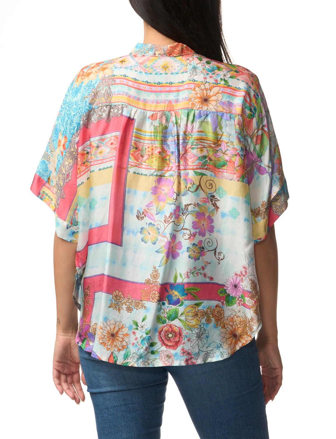 Woman wearing a colorful floral blouse with a white background