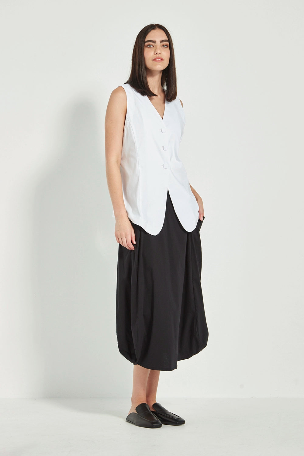 VERGE Acrobat Emi Skirt in Black with soft basque waist, pockets and draped side panels, modern women’s skirt available at Hollie Rose.
