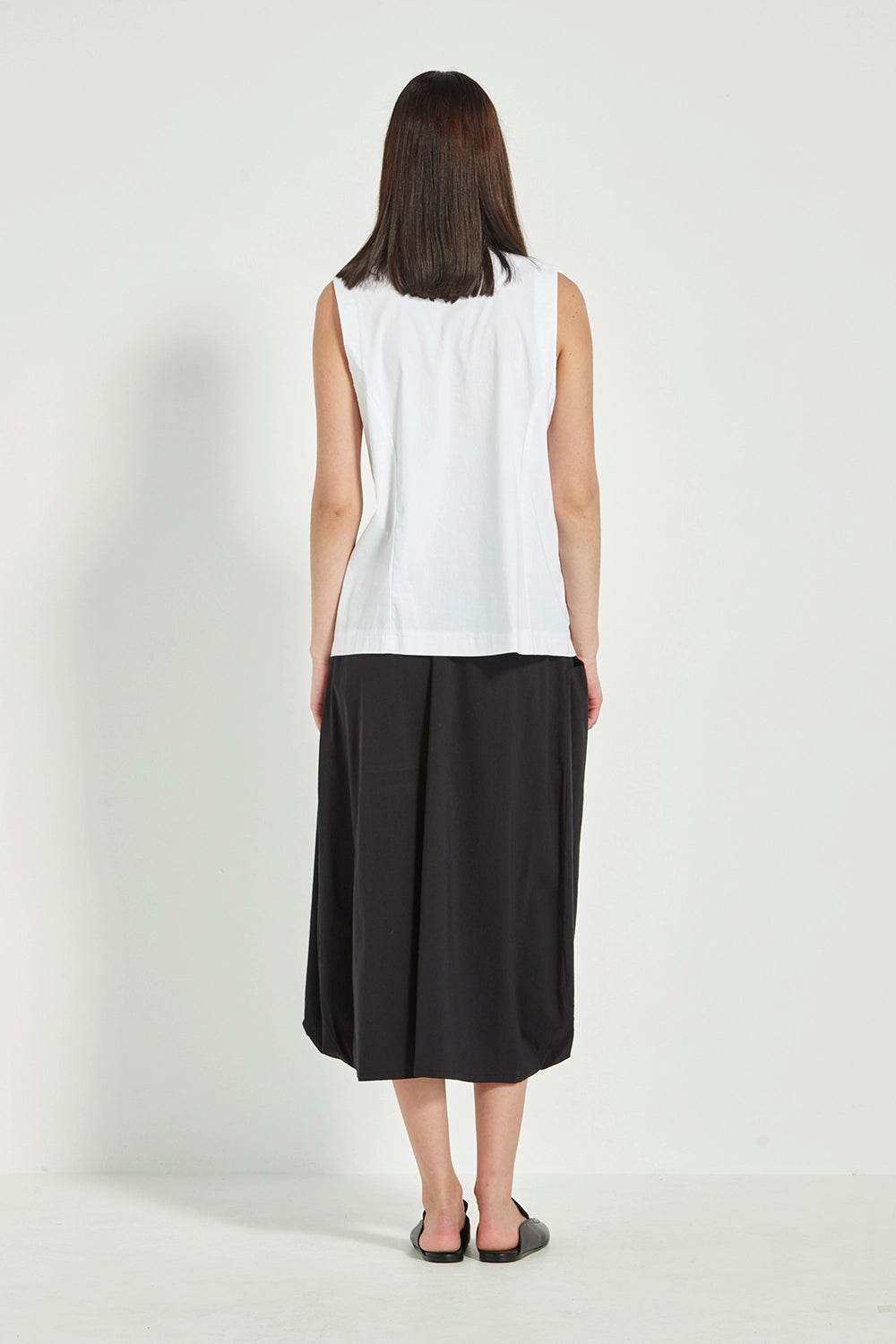 VERGE Acrobat Emi Skirt in Black with soft basque waist, pockets and draped side panels, modern women’s skirt available at Hollie Rose.
