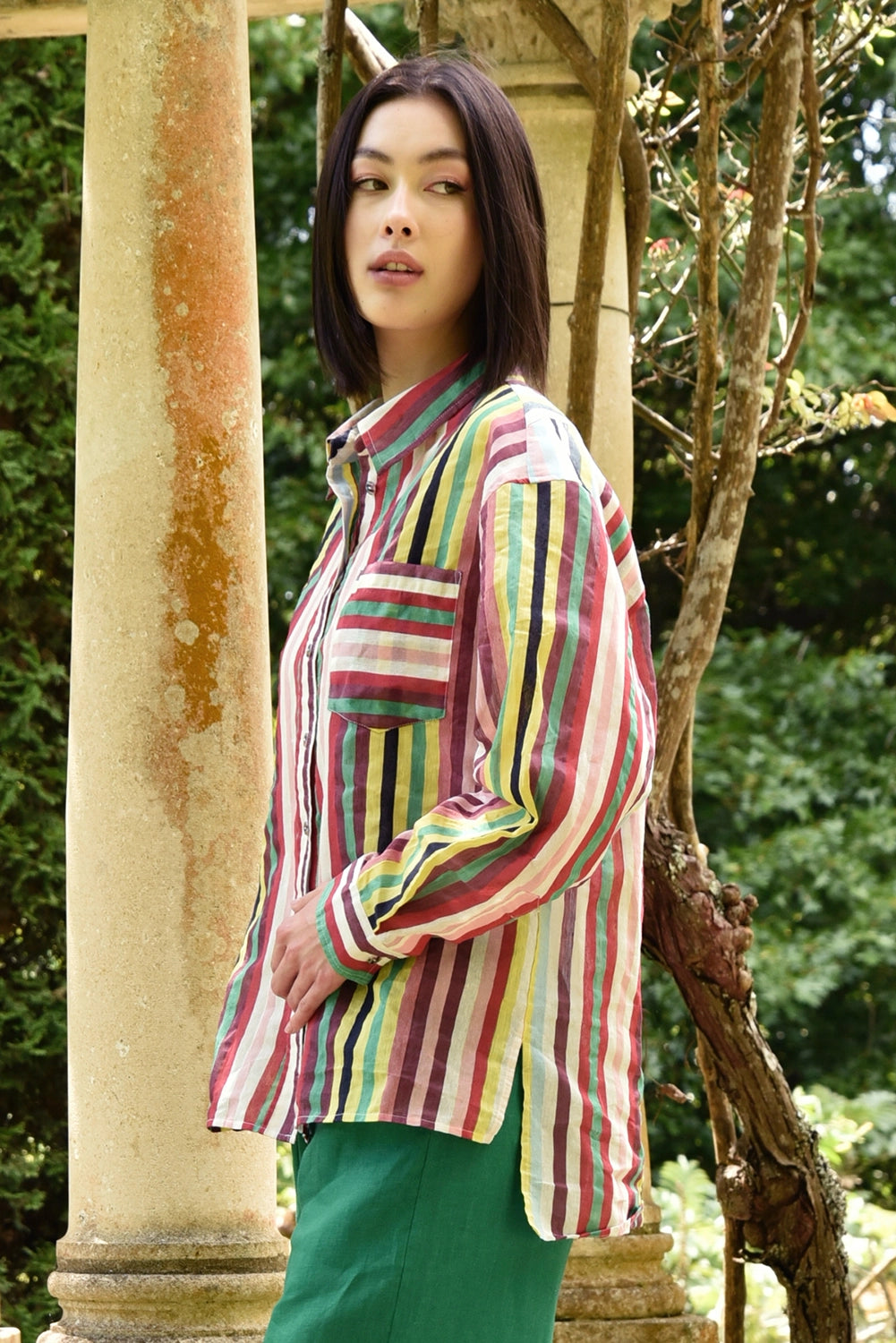 Woman wearing a colorful striped shirt in a garden setting