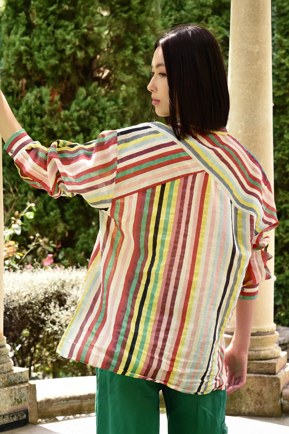 Woman wearing a colorful striped shirt in an outdoor setting
