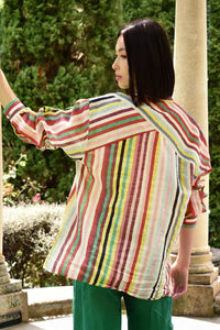 Woman wearing a colorful striped shirt in an outdoor setting