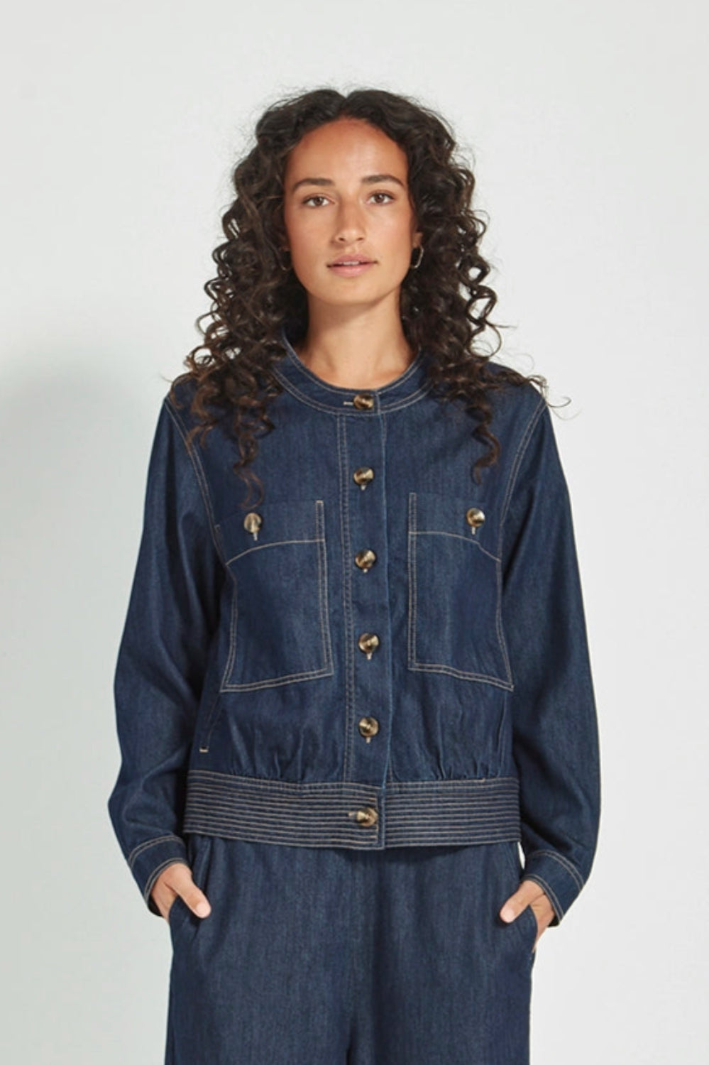 Person wearing a blue denim outfit on a white background